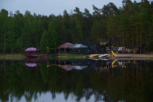 a building on the shore of a body of water at Kempings Bejas in Babīte