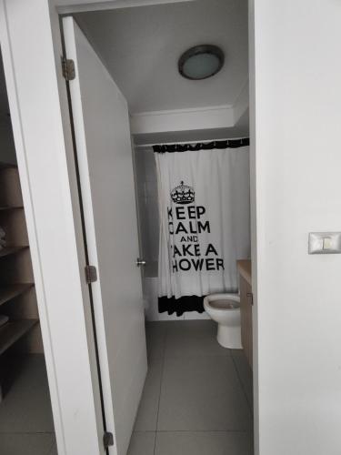 a bathroom with a toilet and a shower curtain at Sector Av. Brasil 1D1B - 4P edificio in Antofagasta