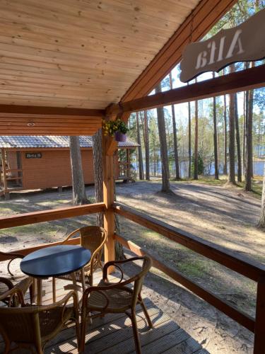a porch with chairs and a table in a cabin at Kempings Bejas in Babīte