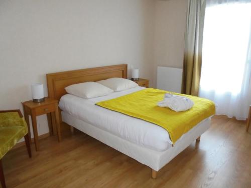 パルトネーにあるドミティ ル シャトー デ プランのベッドルーム1室(黄色い毛布付きのベッド1台付)