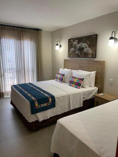 a bedroom with a large bed with two pillows at Resort Quinta Santa Barbara 30 dez 2025 a 06 jan 2026 in Pirenópolis