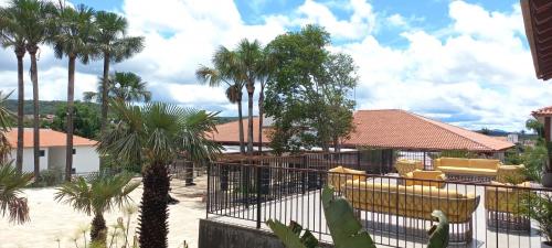 einen Innenhof mit Palmen und gelben Stühlen in der Unterkunft Resort Quinta Santa Barbara 18 a 24 Agosto in Pirenópolis