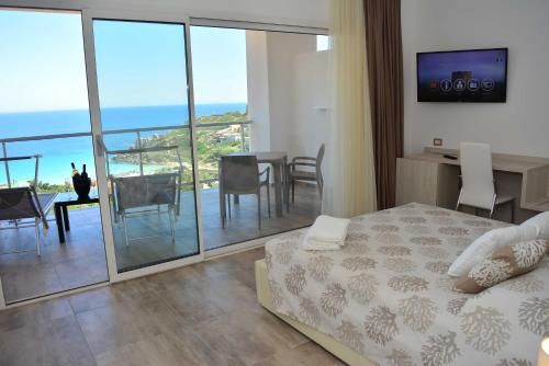 a bedroom with a bed and a balcony with a table and chairs at Hotel La Contessa in Santa Teresa Gallura