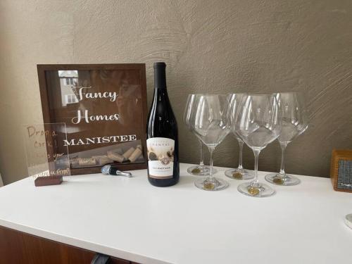 a bottle of wine and two wine glasses on a counter at Fancy Homes Manistee B with Lake View! in Manistee