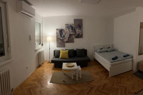 mały salon z łóżkiem i stołem w obiekcie Apartman Luka w mieście Filmski Grad