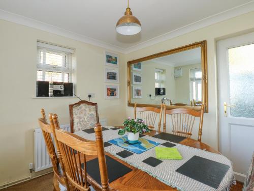 a dining room with a table and a mirror at See The Sea in Hunstanton
