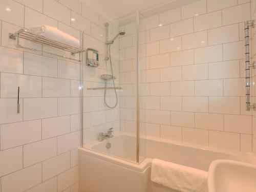 a bathroom with a shower and a tub and a sink at See The Sea in Hunstanton