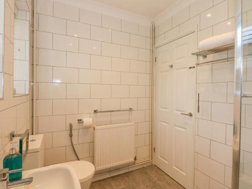 a bathroom with a white toilet and a sink at See The Sea in Hunstanton