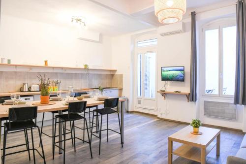 Il comprend une cuisine et un salon avec une table et des chaises. dans l'établissement Vieux-Port Grand appartement 2 ch avec terrasse, à Marseille