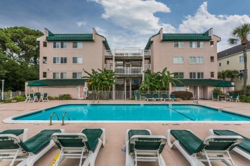 a swimming pool with chairs and a building at Shipwatch 304 in East End