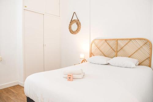 Dormitorio blanco con cama blanca y cabecero dorado en Appartement 1 ch à 1 min de la plage des Catalans, en Marsella