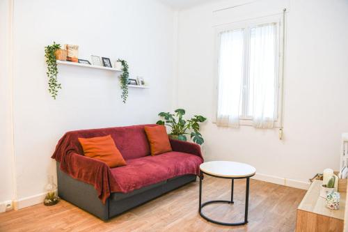 - un salon avec un canapé rouge et une table dans l'établissement Appartement 1 ch à 1 min de la plage des Catalans, à Marseille