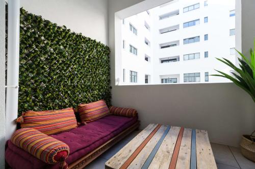 eine lila Couch auf einem Balkon mit grüner Wand in der Unterkunft Le Mazenod - Appartement avec balcon et parking in Marseille