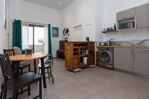 eine Küche mit einem Tisch und einer Waschmaschine in der Unterkunft Le Mazenod - Appartement avec balcon et parking in Marseille