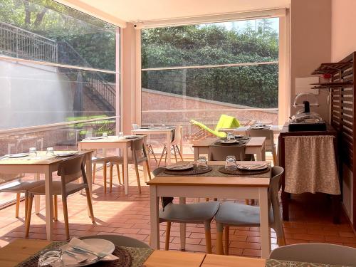 een restaurant met tafels en stoelen en een groot raam bij B&B Villa Paradiso in Urbino