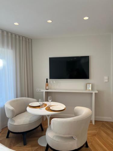 a living room with a table and chairs and a tv at O verso du Château - STUDIO 11 in Barr