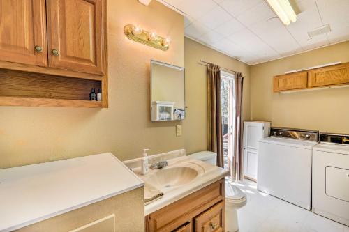 a bathroom with a sink and a washer and dryer at Cozy Lakeside Escape with Deck 4 Mi to Rainbow Lake in Pinetop-Lakeside