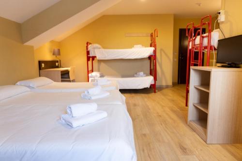 a room with three beds with white towels on them at Hotel Port 1730 in La Coma i la Pedra