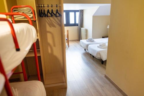 a view of a room with two beds and a doorway at Hotel Port 1730 in La Coma i la Pedra
