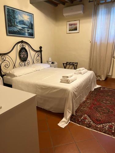 a bedroom with a large bed with white sheets at Villa Schiatti in Cortona