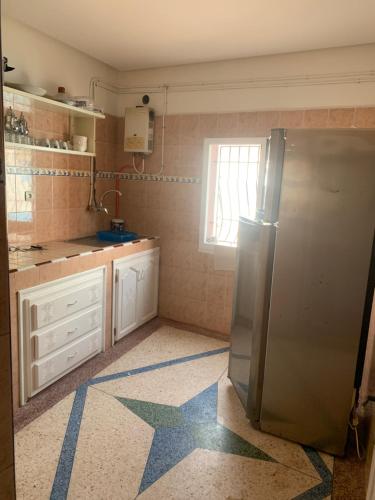 a kitchen with a refrigerator and a star on the floor at Appartement, tilila in Mirleft