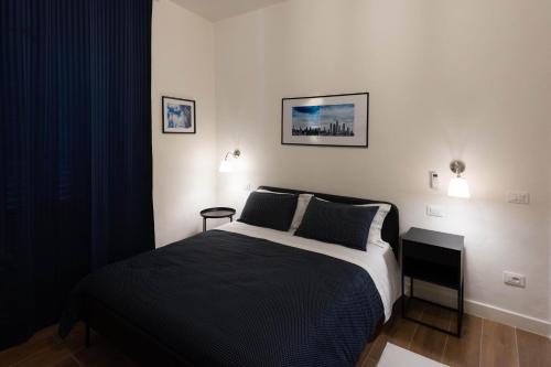 una camera con un letto bianco e nero e un tavolino di B&B Porta 93 a Pistoia