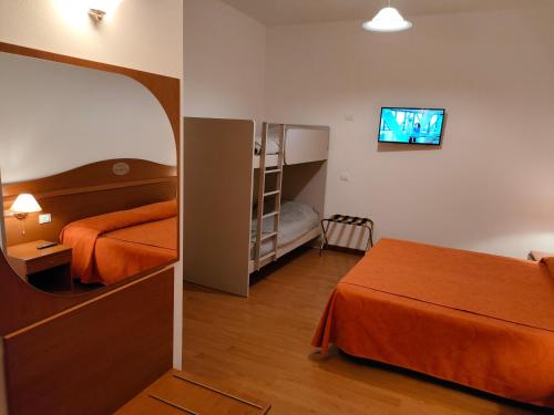CastelgombertoにあるAlloggio Al Ponteのベッドとテレビが備わるホテルルームです。