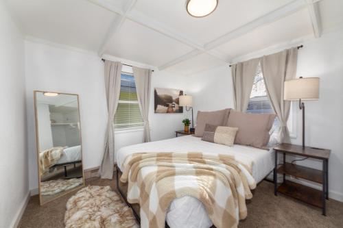 Habitación blanca con cama y espejo en Adorable 2 BD 1 BTH Home Minutes Away from Gonzaga, en Spokane
