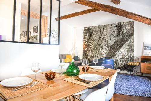a dining room with a wooden table and chairs at Grand appartement 2 chambres avec vue Vieux-Port in Marseille