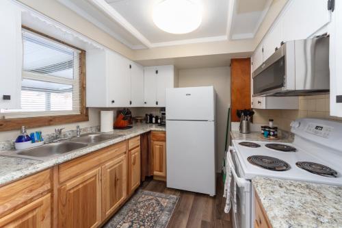 a kitchen with a white refrigerator and a sink at Adorable 2 BD 1 BTH Home Minutes Away from Gonzaga in Spokane
