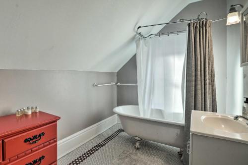 La salle de bains est pourvue d'une baignoire, d'un lavabo et d'une commode rouge. dans l'établissement Saint Paul Home in Historic Cathedral Hill, à Saint Paul