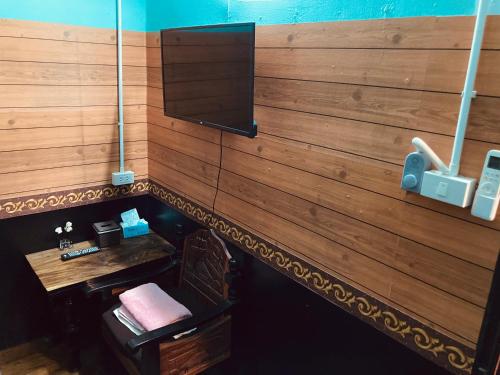 a room with a wooden wall with a television at โรงแรมคุ้มเดช - KoomDech Hotel in Sattahip