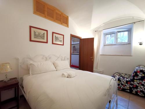 1 dormitorio con 1 cama blanca y 1 silla en Colosseo Home - 29061 en Roma