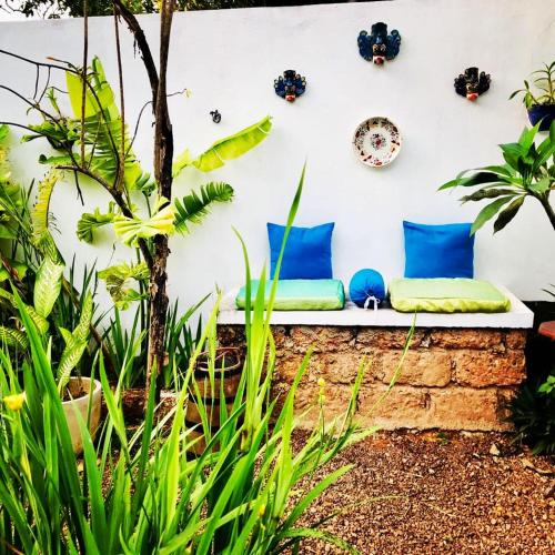 a bench in a garden with blue pillows and plants at Sriyan Villa in Beruwala