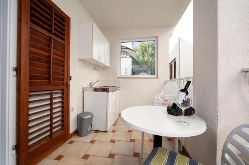 a small kitchen with a white table and a window at Villa Fina in Tučepi