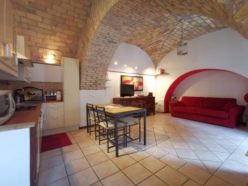 eine Küche und ein Wohnzimmer mit einem roten Sofa in der Unterkunft Colosseo Home - 29061 in Rom