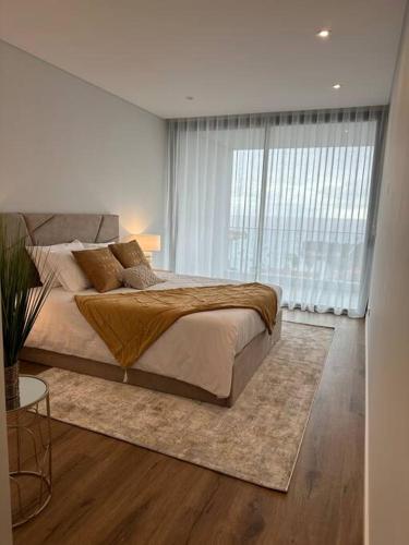 a bedroom with a large bed and a large window at Deluxe Bay View in Câmara de Lobos