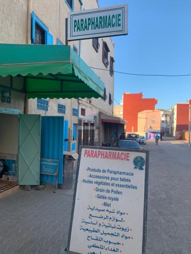 a sign on a street in front of a building at Appartement, tilila in Mirleft