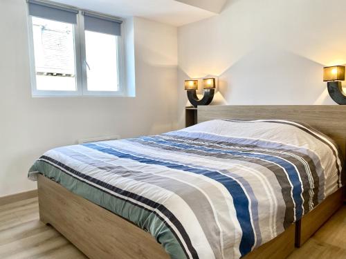 - une chambre avec un lit doté d'une couverture rayée dans l'établissement Appartement Léonard, comme à la maison - Vieux Lille, à Lille