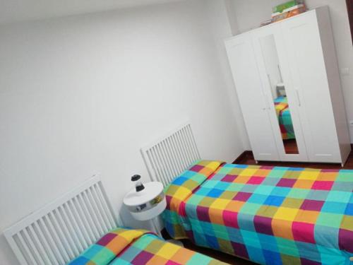 1 dormitorio con 2 camas individuales y espejo en TESOROS DE CANTABRIA apart.Luna G101687, en Ampuero