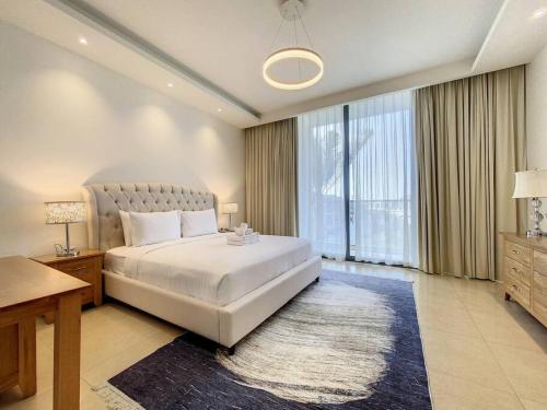 a bedroom with a large bed and a large window at Key View - Villa Gardenia Jebel Ali in Dubai
