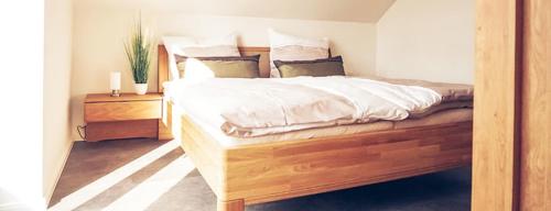 a bedroom with a large wooden bed with white sheets at Ferienwohnungen Stührenberg - Wohnung 3 in Schwanewede