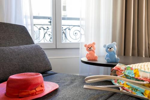 a red hat and two teddy bears on a table at Hotel 66 Nice in Nice
