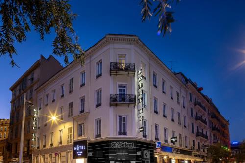 a large white building on a city street at night at Hotel 66 Nice in Nice