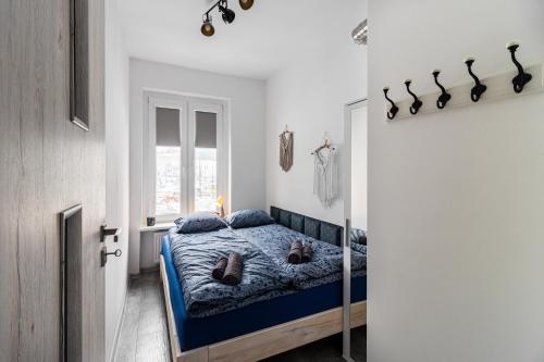 a bedroom with a bed with a blue comforter at Wszędzie blisko in Gliwice