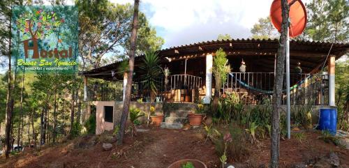 a wooden building with a porch with plants at Brisas de San Ignacio in San Ignacio