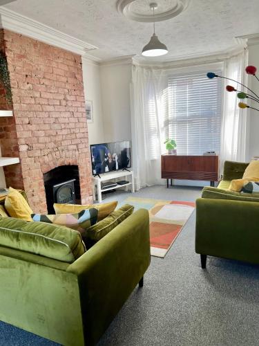 a living room with two couches and a fireplace at Contemporary 2 Bedroom Victorian Town House - Sleeps up to 6 in Kimberley