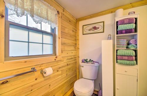 a bathroom with a toilet and a window at Florence Cabin with On-Site Creek! in Florence