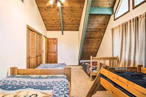 um quarto com 3 camas num quarto com tectos em madeira em Lake Arrowhead Cabin with Lush Yard about 5Mi to Village! em Lake Arrowhead