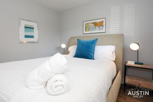 a bedroom with a large white bed with blue pillows at Bright Space Close To Best Beer Gardens Coffee in Austin